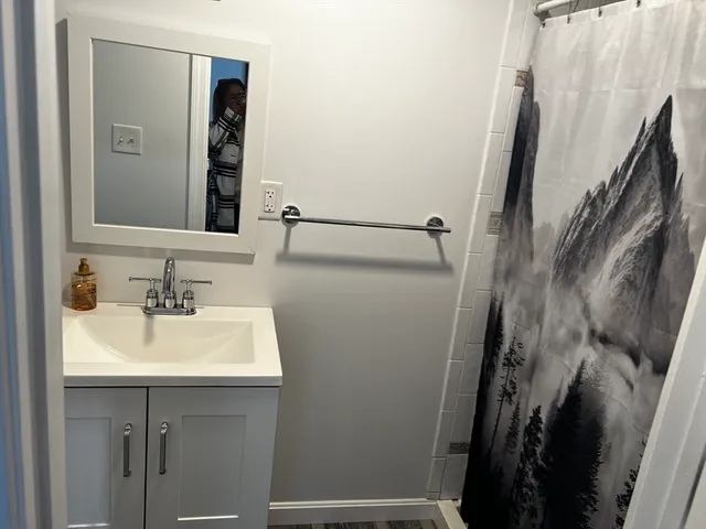 a bathroom with a sink a mirror and shower