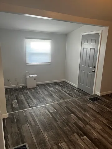 a view of a livingroom with wooden floor and window