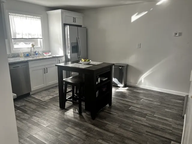a kitchen with a table chairs sink and cabinets