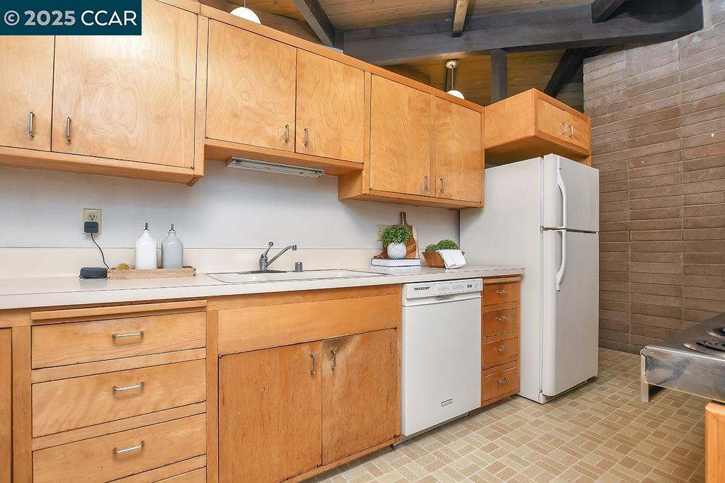 a kitchen with stainless steel appliances granite countertop a sink a stove a refrigerator and cabinets with wooden floor