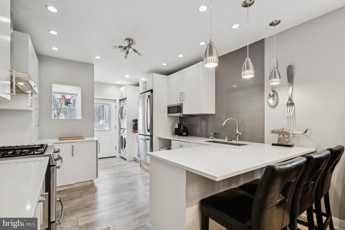 9 North Lenola Road Moorestown, NJ 08057 - Photo 8 of 25 a kitchen with stainless steel appliances a stove a sink a kitchen island with chairs and wooden floor