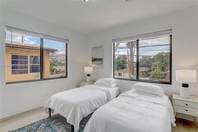 a bedroom with two beds and a large window