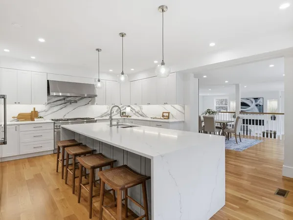a kitchen with kitchen island white cabinets and refrigerator