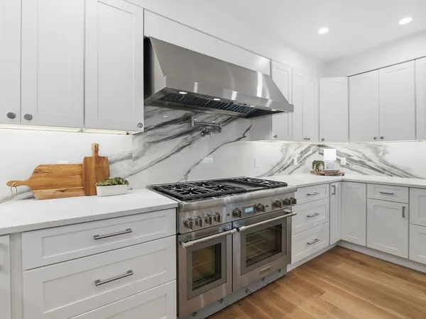 a kitchen with granite countertop white cabinets and white appliances