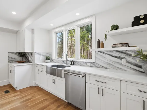 a kitchen with stainless steel appliances granite countertop a sink a stove and a refrigerator