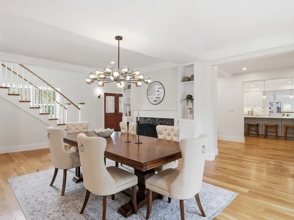 a dining room with furniture a fireplace and wooden floor