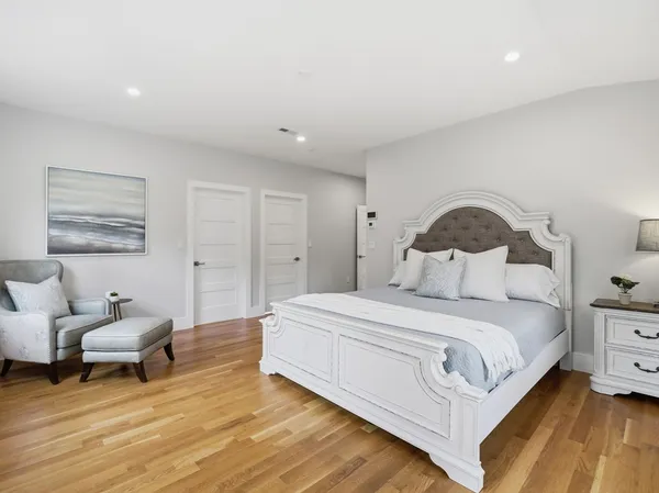 a bedroom with a bed and wooden floor