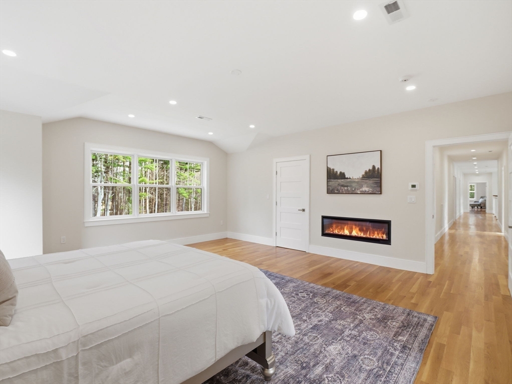 22 Lincoln Road Lincoln, MA 01773 - Photo 30 of 42 a spacious bedroom with a bed and a painting on the wall