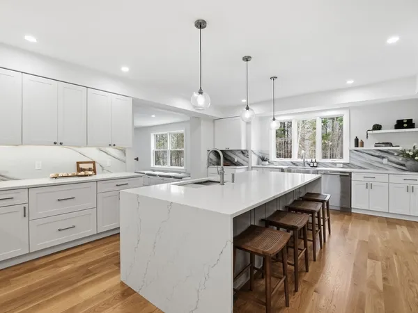 a kitchen with kitchen island a stove a table a sink and cabinets
