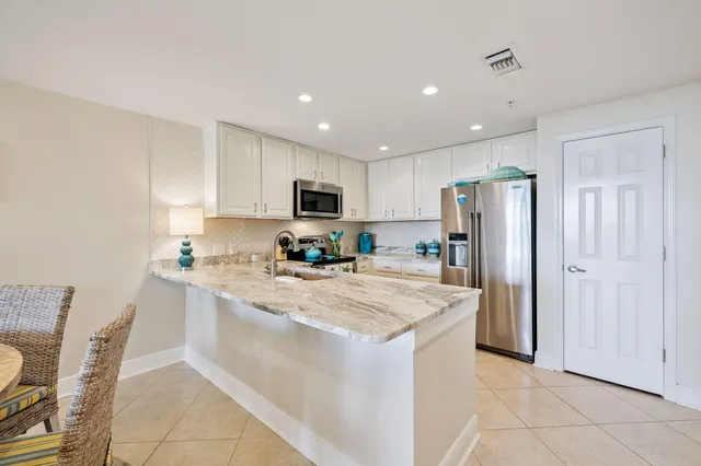 a kitchen with stainless steel appliances a refrigerator sink and microwave