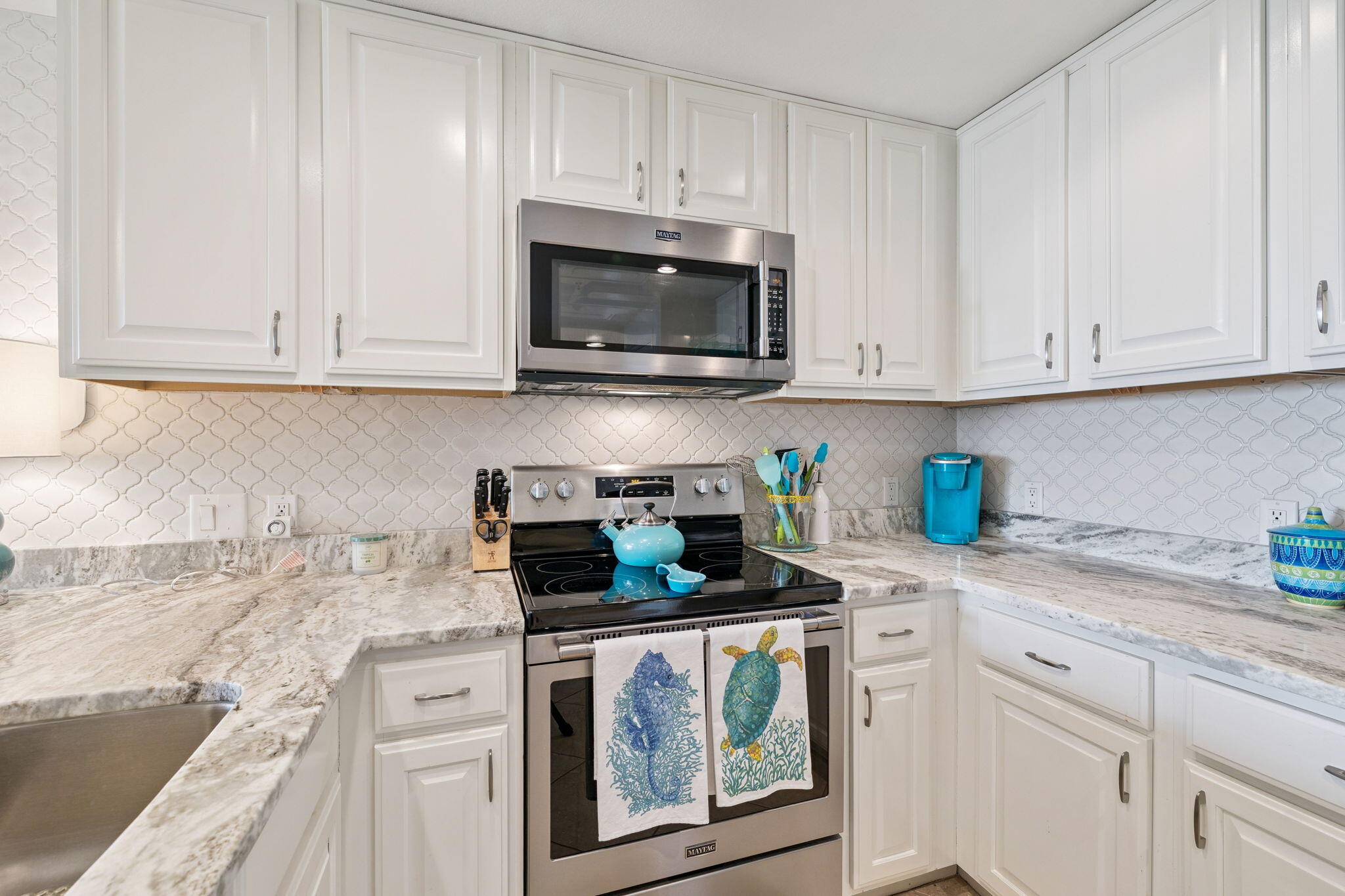 4045 West County Highway 30A, Unit 108 Santa Rosa Beach, FL 32459 - Photo 6 of 29 a kitchen with granite countertop white cabinets and stainless steel appliances