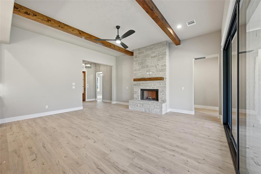 1053 Llano Way Poolville, TX 76487 - Photo 9 of 40 a view of empty room with wooden floor and fireplace