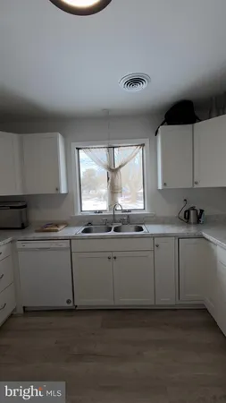 a kitchen with granite countertop white cabinets and a dishwasher