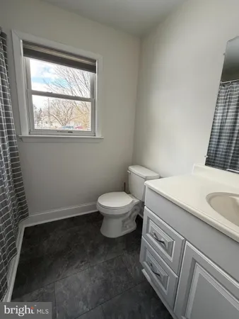 a bathroom with a toilet a sink and a window