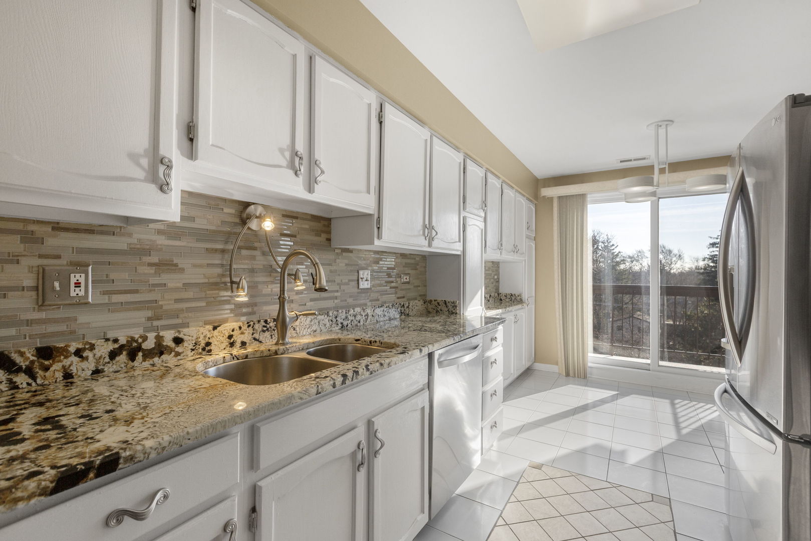 400 East Dundee Road, Unit 403C Buffalo Grove, IL 60089 - Photo 7 of 20 a kitchen with stainless steel appliances granite countertop a sink a stove and white cabinets