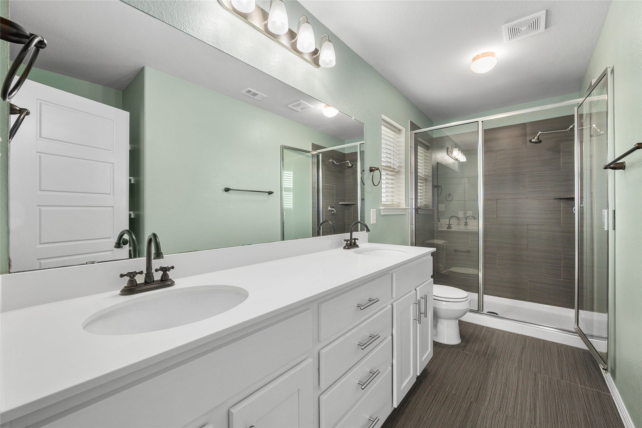 101 Lambert Street Leander, TX 78641 - Photo 19 of 33 A refreshing bathroom offering a dual vanity with ample storage and a spacious glass-enclosed shower.