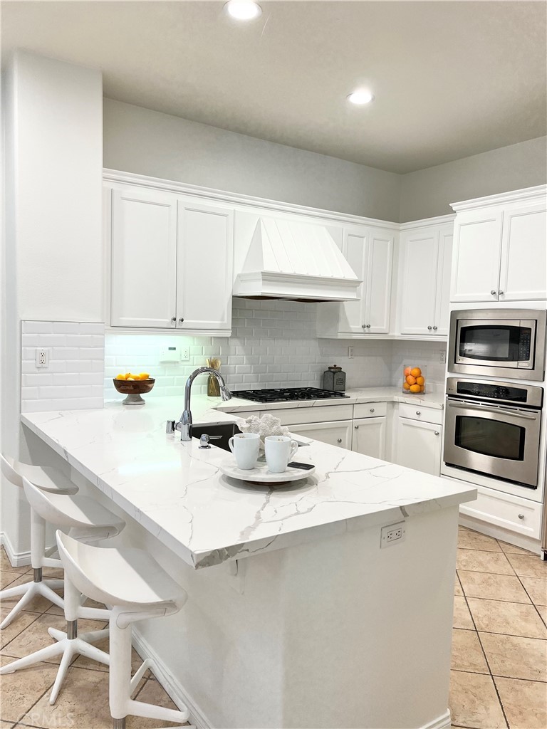 22 San Sovino Newport Coast, CA 92657 - Photo 10 of 20 a kitchen with a sink a stove a microwave and cabinets