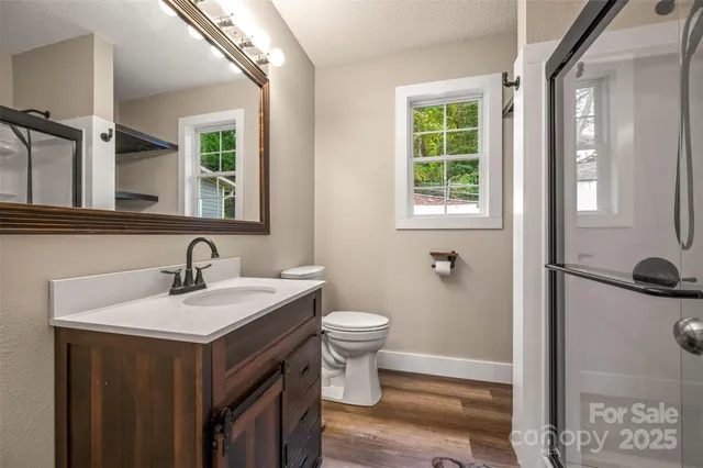 a bathroom with a sink a toilet and shower