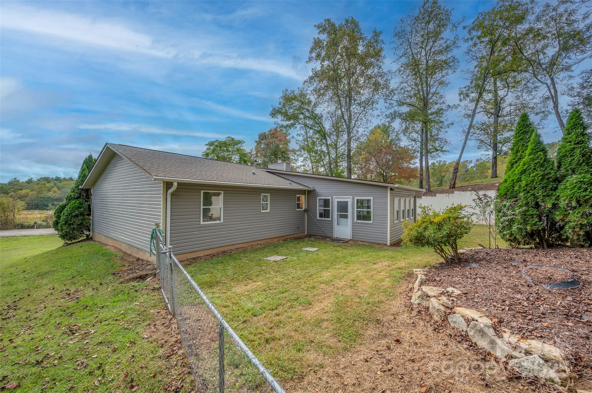 569 Lanning Road Hendersonville, NC 28792 - Photo 30 of 32 a view of a house with a large tree and a yard