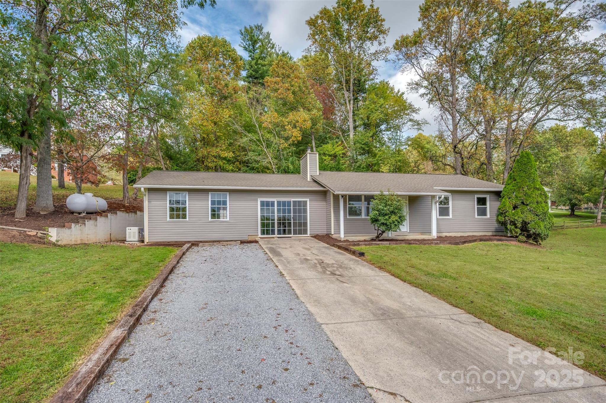 569 Lanning Road Hendersonville, NC 28792 - Photo 3 of 32 a view of house with a big yard and large trees