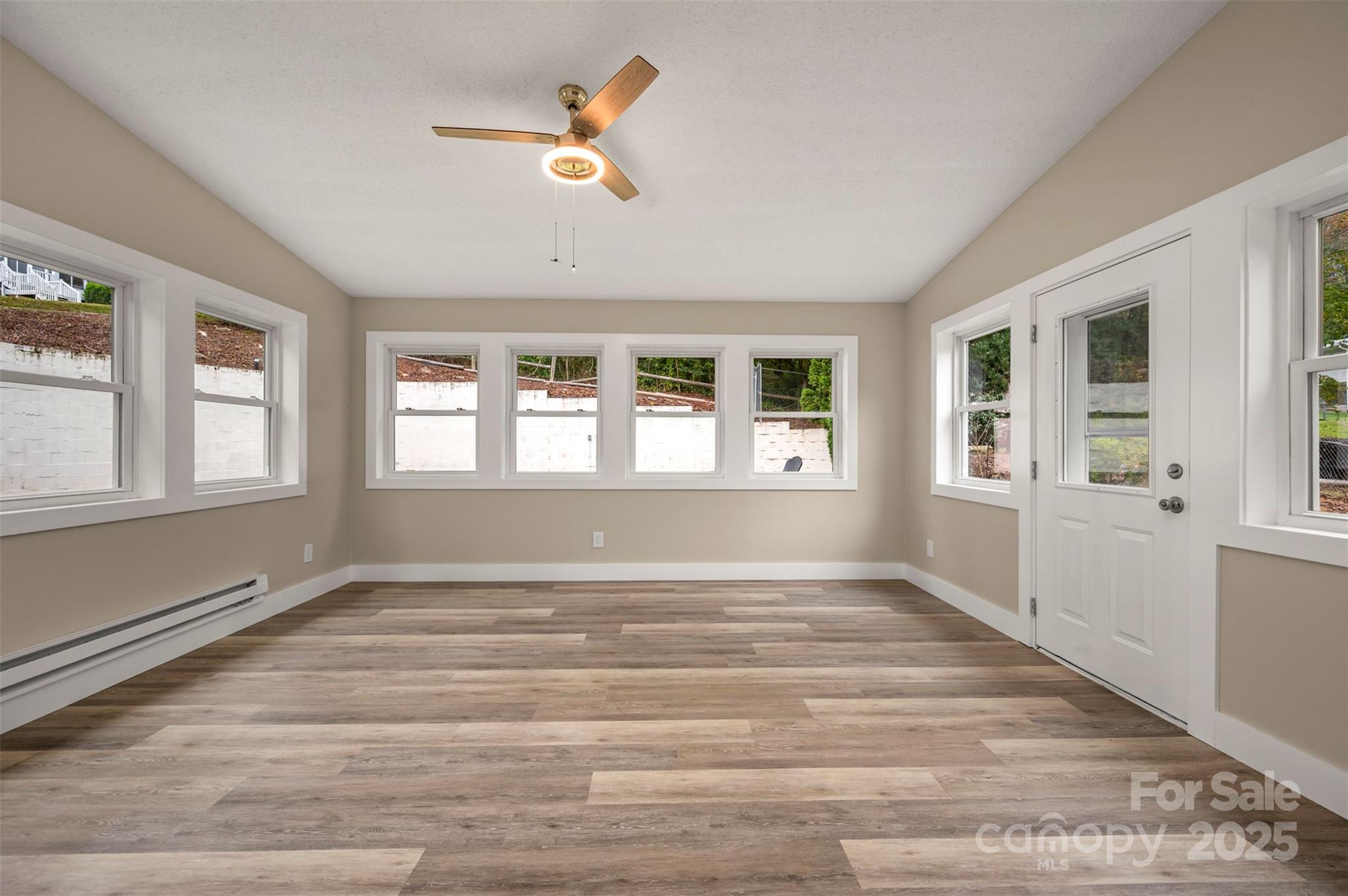 569 Lanning Road Hendersonville, NC 28792 - Photo 10 of 32 a view of an empty room with wooden floor and a window