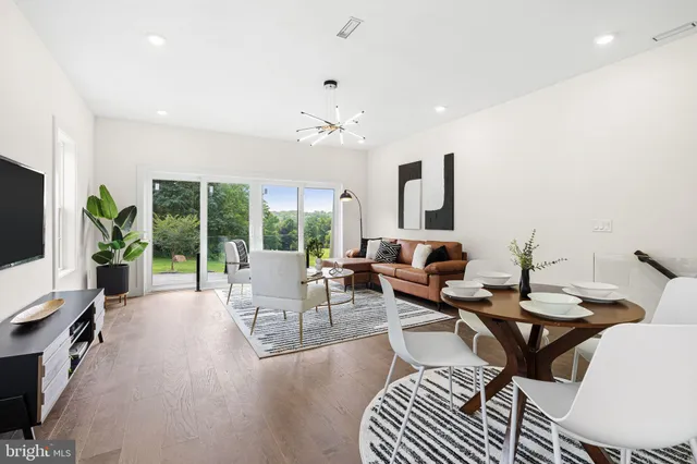 a living room with furniture a flat screen tv and a large window