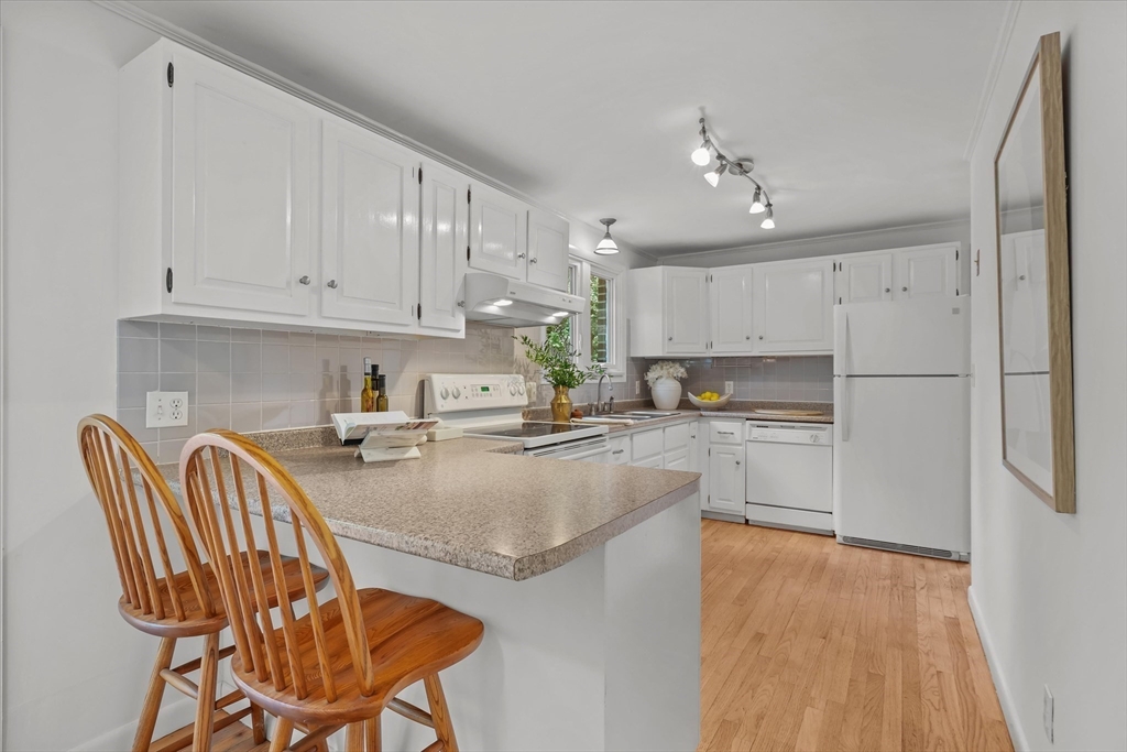 50 Middle Road Amesbury, MA 01913 - Photo 7 of 30 a kitchen with stainless steel appliances granite countertop a refrigerator a sink dishwasher a stove and white countertops with wooden floor