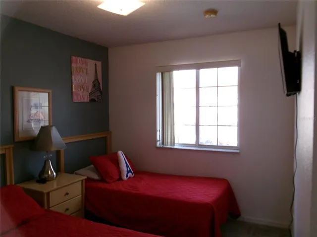 a bedroom with a bed and window with lamp