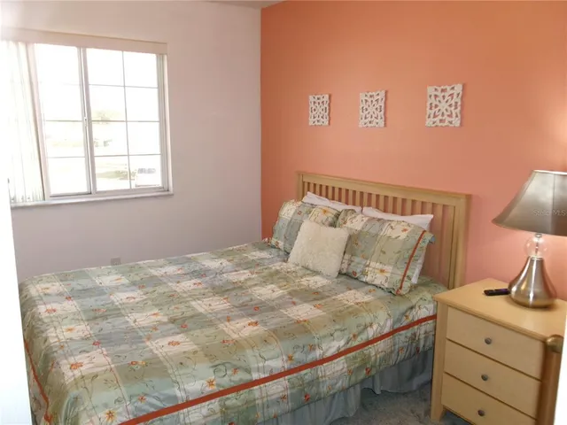 a bedroom with a bed and flat tv screen on the dresser