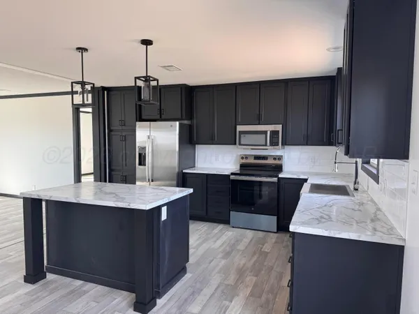 a kitchen with a refrigerator sink and stove