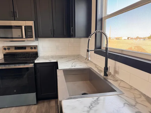 a kitchen with a sink and a stove top oven