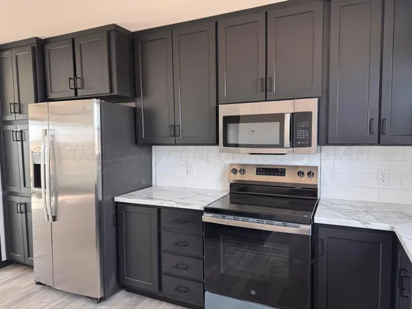 a kitchen with a refrigerator stove and microwave