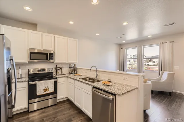 a kitchen that has a sink and a stove top oven