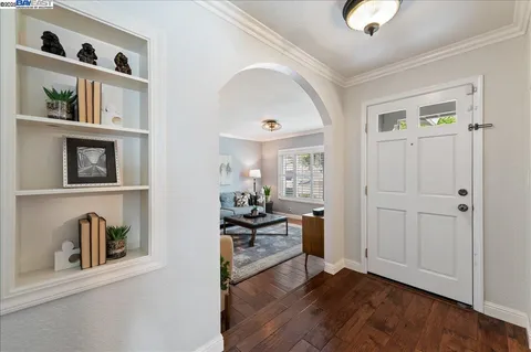 a view of a livingroom with furniture wooden floor cabinet and mirror