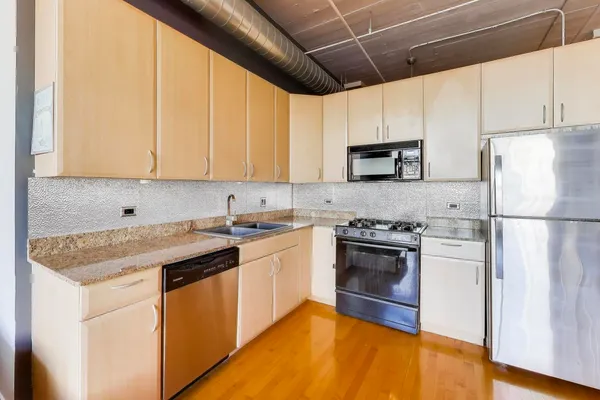a kitchen with stainless steel appliances granite countertop a stove a sink and a refrigerator