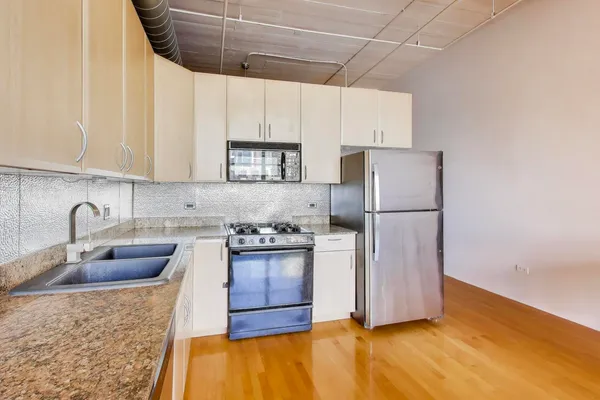 a kitchen with a refrigerator sink and cabinets