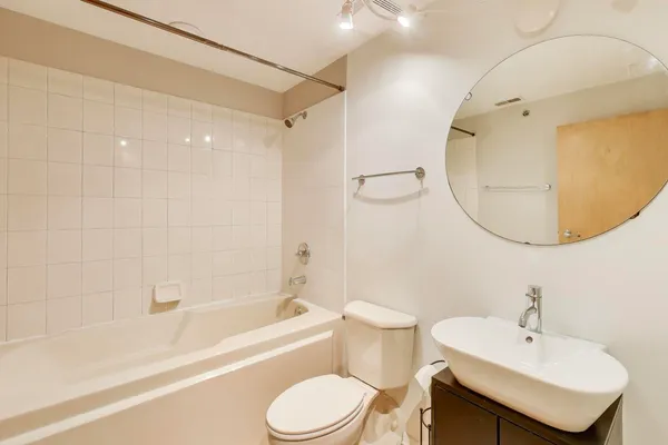 a bathroom with a sink a toilet and a mirror