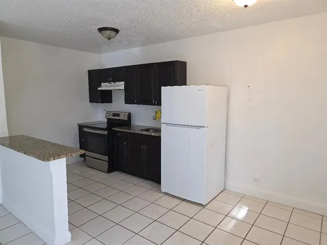 a kitchen with a refrigerator and a stove