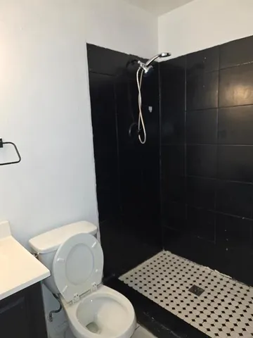 a bathroom with a toilet and a shower