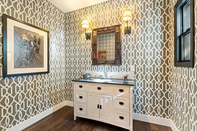 a view of a hallway with wooden floor and furniture
