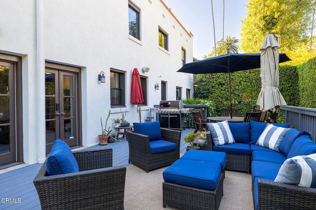 a balcony with wooden floor and outdoor seating