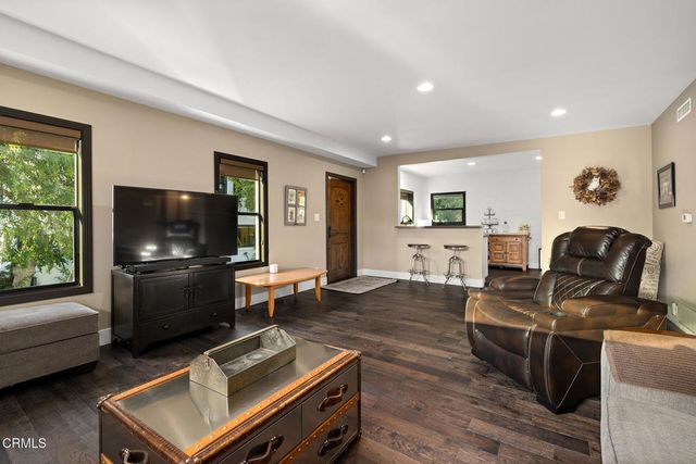 a kitchen with stainless steel appliances granite countertop a refrigerator a sink dishwasher and a stove with wooden floor