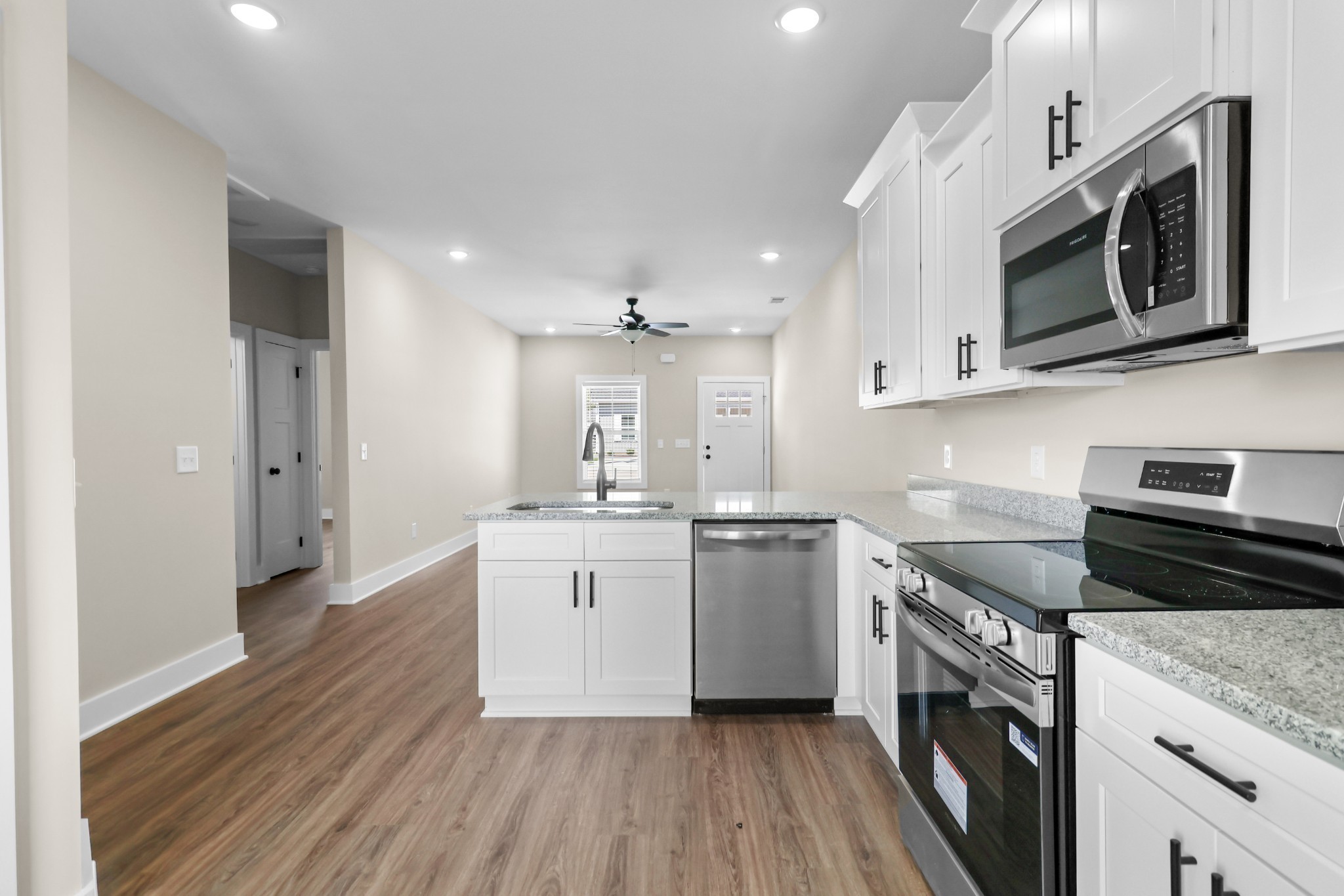 1007 Oak Street, Unit A Portland, TN 37148 - Photo 6 of 29 a kitchen with stainless steel appliances granite countertop a sink a stove a microwave and cabinets
