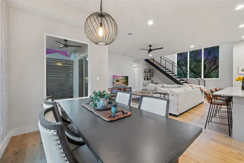 a kitchen with stainless steel appliances a sink a stove a refrigerator cabinets and dining table