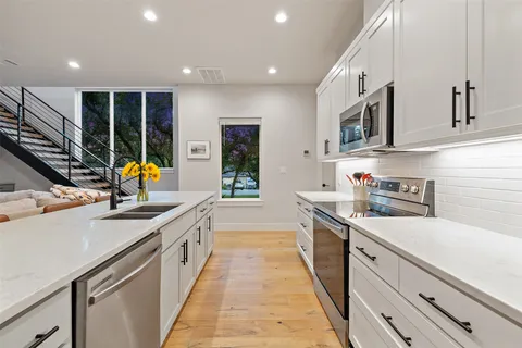 a kitchen with a sink a counter top space and stainless steel appliances