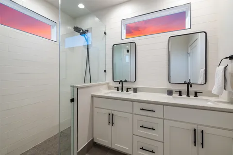 a bathroom with a double vanity sink and a mirror