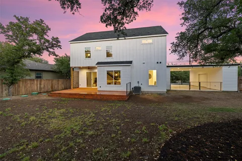 a view of a house with backyard and a tree