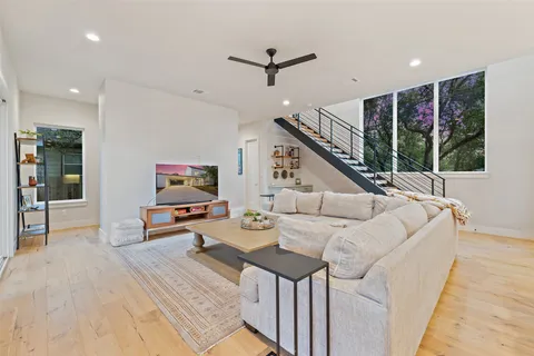 a living room with stainless steel appliances kitchen island granite countertop furniture wooden floor and a view of kitchen