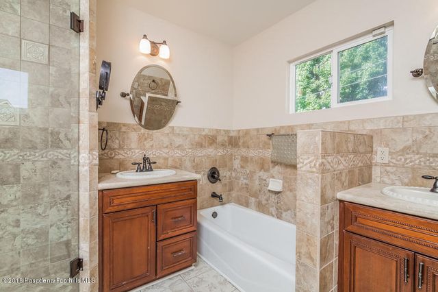 a bathroom with a tub sink and mirror
