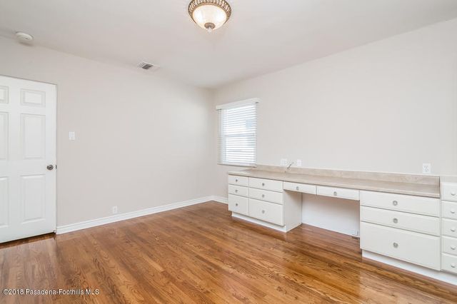 a view of a kitchen with wooden floor and cabinets
